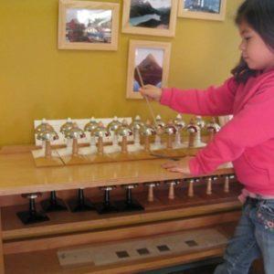 A girl learning to play bells at the Montessori school in Roseville, MN-4c77ea6575