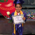Child in cap and gown at kindergarten graduation
