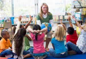 Kindergarten Teacher and Children with Hands Raised — Minneapolis, MN — Miniapple International Montessori